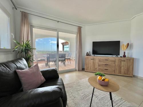 a living room with a couch and a television at Beautiful apartment with golf and mountains view in Sucina