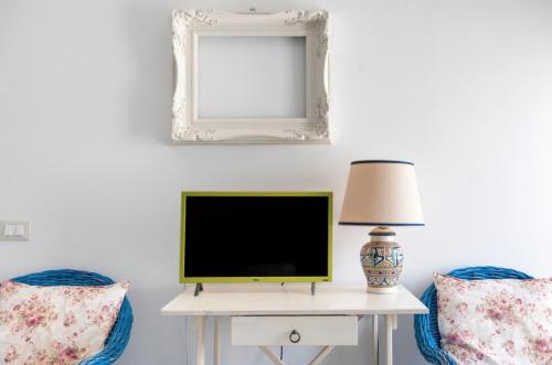 a tv on a table with two chairs and a mirror at Le Terrazze in Otranto