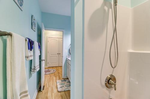 a bathroom with blue walls and a shower with towels at Walk to Bay Home with Fenced Yard in Colonial Beach in Colonial Beach