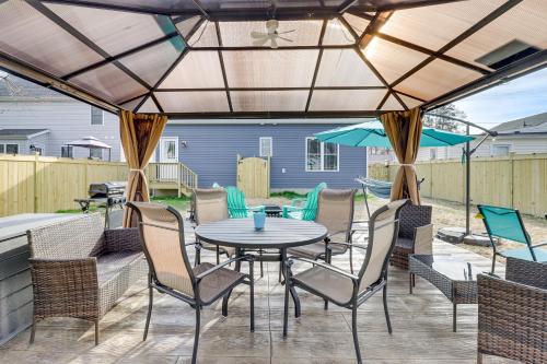a patio with a table and chairs and an umbrella at Walk to Bay Home with Fenced Yard in Colonial Beach in Colonial Beach