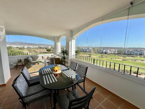 a living room with a table and chairs and a large window at Beautiful apartment with golf and mountains view in Sucina