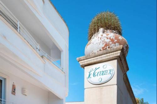 a sign on a building with a plant on top at Le Terrazze in Otranto