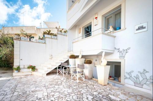a white building with stairs and chairs in a courtyard at Le Terrazze in Otranto