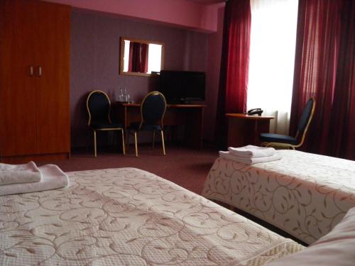 a hotel room with a bed and a table and chairs at Hotel Horyzont in Rzeszów