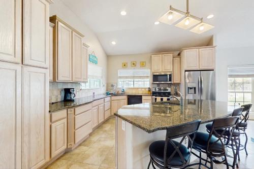 a kitchen with wooden cabinets and a island with bar stools at Myrtle in Rockport