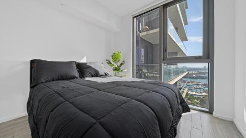 a bedroom with a large black bed and a large window at 2-Bedr Downtown Miami Condo Bay Views in Miami