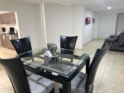 a glass table with chairs and a dining room at Apartamento en el centro de Tuluá in Tuluá