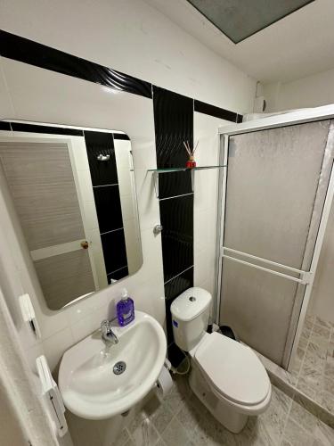 a bathroom with a white toilet and a sink at Apartamento en el centro de Tuluá in Tuluá