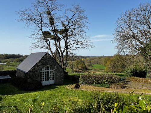 a small stone building in a field with a tree at Gîtes du Gohic in Quistinic