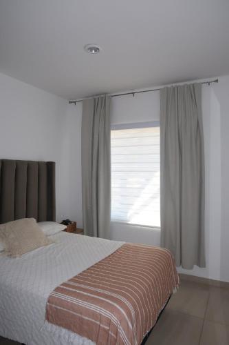 a bedroom with a bed and a window at apartment 5 minutes from the beach in Mazatlán