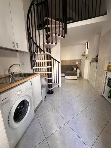 a kitchen with a washing machine and a staircase at La casa di vale in Molfetta