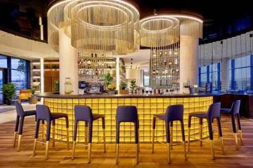 a bar with chairs and a table in a building at Courtyard by Marriott Lyon Eurexpo Stadium in Genas