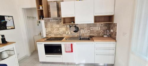 a kitchen with white cabinets and a sink at Casa Giardino in Marina di Campo