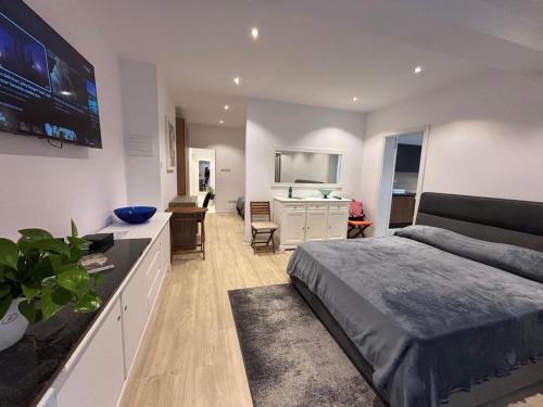 a bedroom with a bed and a desk and a kitchen at Sliema Maisonette in city center in Sliema