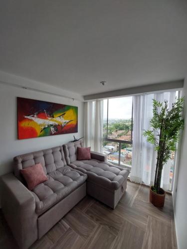 a living room with a couch and a large window at Apartasuite Privado Espectacular Vista Panorámica cerca al HIC FOSCAL 3 Habitaciones in Floridablanca