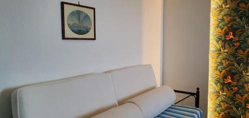 a white couch in a room with a picture on the wall at Blu Home in Massa Lubrense