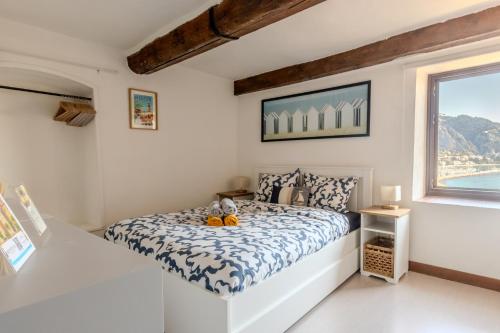 une chambre blanche avec un lit et une fenêtre dans l'établissement Duplex Vieille ville - SEA VIEW, à Menton