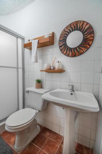 a bathroom with a toilet and a sink and a mirror at Hotel el Tajalin in Montezuma