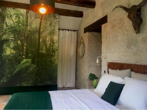 - une chambre avec un lit et un tableau représentant une forêt dans l'établissement Le mas d'argile, charming holiday rental - private pool & views, à Saint-Cyprien