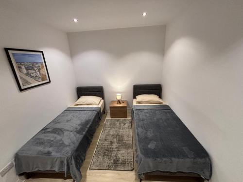 two twin beds in a room with a table at Sliema Maisonette in city center in Sliema