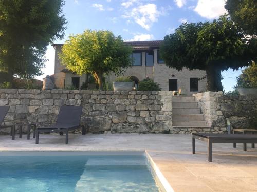 une maison avec un mur en pierre et une piscine dans l'établissement Le mas d'argile, charming holiday rental - private pool & views, à Saint-Cyprien
