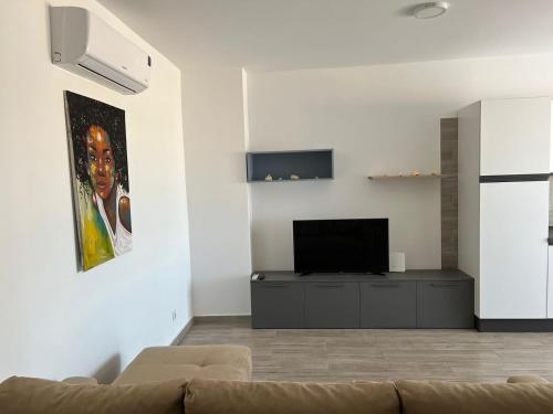 a living room with a couch and a flat screen tv at Appartamenti Praia Estoril, Sal Rei, Boa Vista in Sal Rei