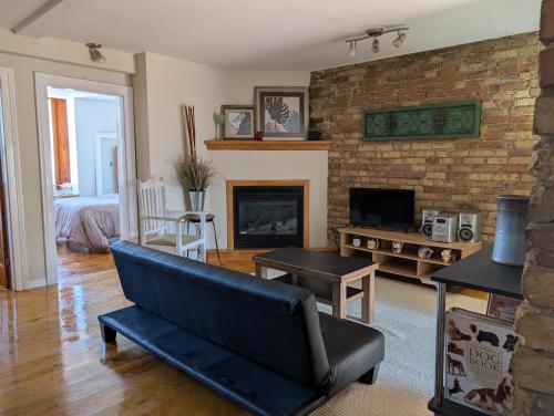 a living room with a couch and a fireplace at Cozy 2-Bedroom Downtown Apartment in London