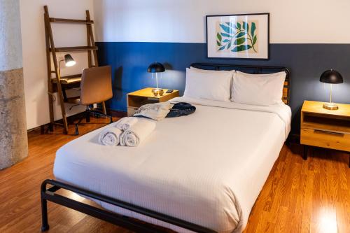 a bedroom with a large white bed and a desk at Sosuite at Independence Lofts - Callowhill in Philadelphia