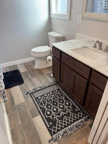 a bathroom with a sink and a toilet and a rug at Cabin 2BR 2BA home, 3 min to airport and downtown in Boise