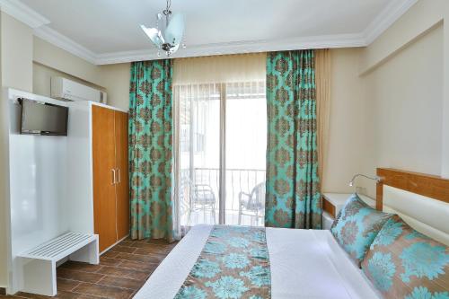 a hotel room with a bed and a balcony at Hotel Kayahan in Kas