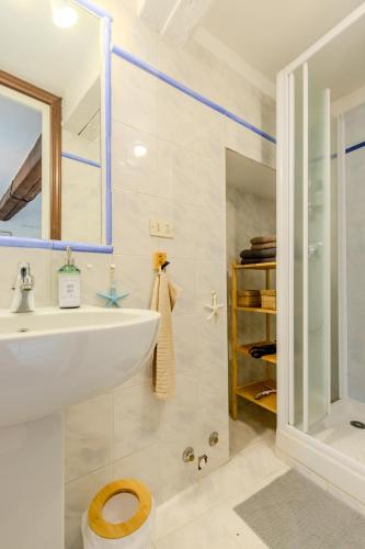 une salle de bain blanche avec un lavabo et une douche dans l'établissement Duplex Vieille ville - SEA VIEW, à Menton