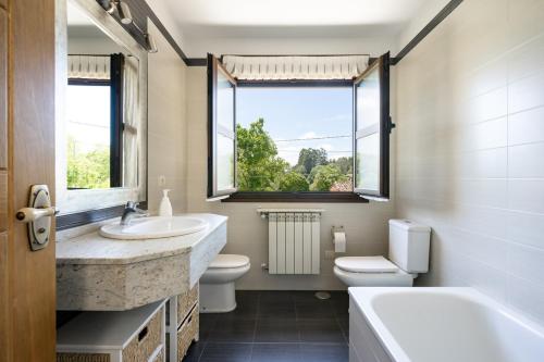 ein Badezimmer mit Waschbecken, Badewanne und Toilette in der Unterkunft La Corvera en Collera, Ribadesella in Collera