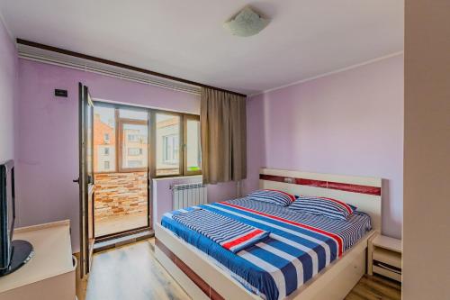 a bedroom with a bed and a window at M Suite - close to the beach in Mangalia