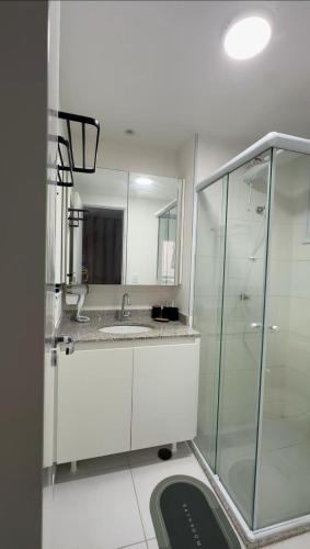 a bathroom with a sink and a glass shower at Nari Loft in São Paulo