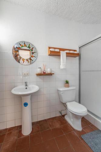 a bathroom with a toilet and a sink at Hotel el Tajalin in Montezuma