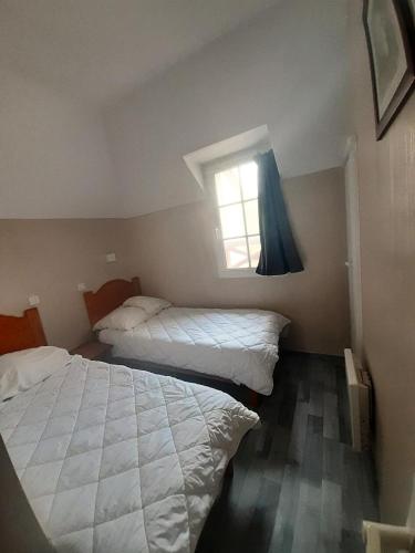 deux lits dans une chambre avec une fenêtre dans l'établissement La résidence du Lac - maeva Home - Maison 3 pièces 6 personnes - Prestige MAE-8044, à Monflanquin