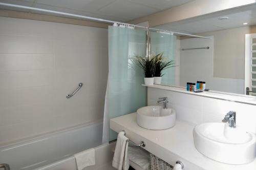 Un baño con dos lavabos y un espejo. en Serennia Exclusive Rooms, en Barcelona