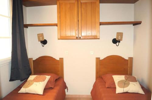 - une chambre avec 2 lits et un placard dans l'établissement La résidence du Lac - maeva Home - Appartement 2 pièces 4 personnes - Sélection MAE-1511, à Monflanquin
