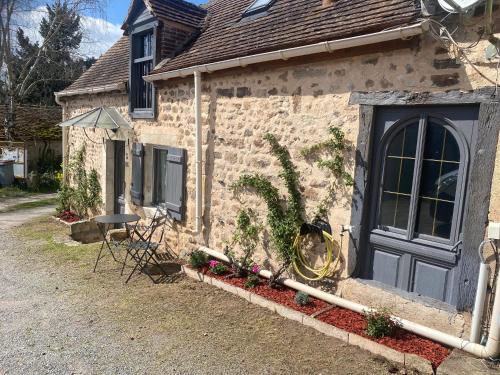 a brick house with a black door and some flowers at La Ptite maison du Canal in Drevant