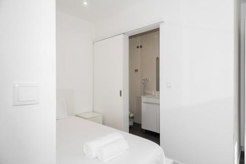 Camera bianca con letto e lavandino di Downtown Lisbon Palma Suites by Hosty a Lisbona