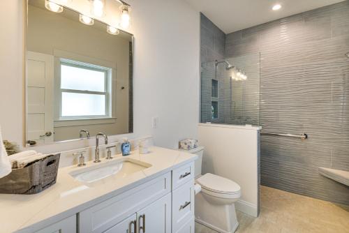 a bathroom with a sink and a toilet and a mirror at Walk to Beach and Central Park Home in Cape Charles in Cape Charles