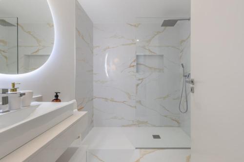 ein weißes Badezimmer mit Waschbecken und Dusche in der Unterkunft Casa da Ilha in Funchal