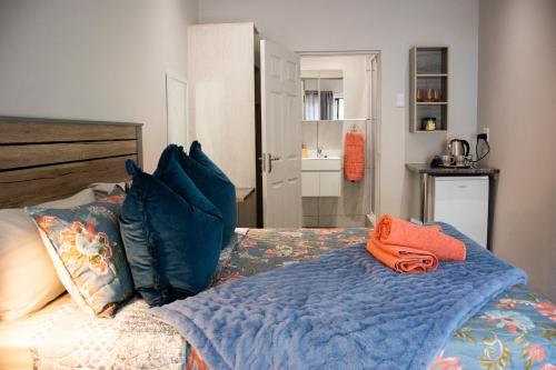 un letto con coperta blu e cuscini sopra di The Garden Manor a Winterton
