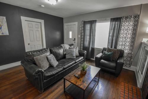 a living room with a leather couch and two chairs at Chic Denver Family Retreat Free Parking & Prime Location in Denver