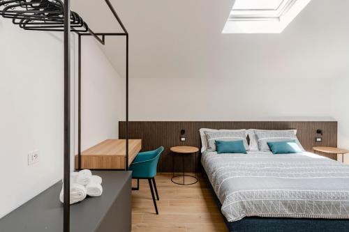 a bedroom with a bed and a blue chair at Sole Luxury terrace,Central apartment in Matera