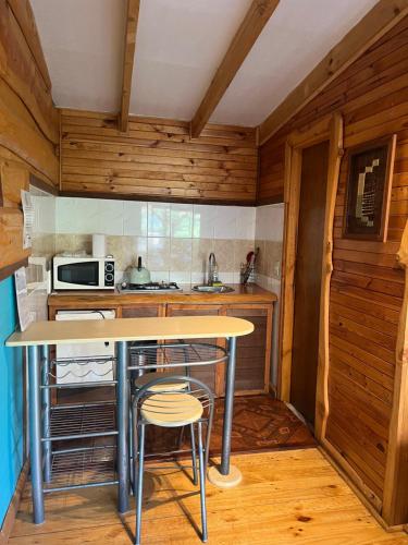ラ・エンセナダにあるCabañas y Camping Barloventoの小さなキッチン(テーブル、スツール2脚付)