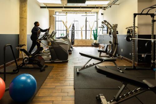 a woman running on a treadmill in a gym at Sosuite at Independence Lofts - Callowhill in Philadelphia