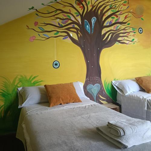 a bedroom with a tree painted on the wall at NAMASTÉ Avenida Compostela 6, 4B sin ascensor in Palas de Rei
