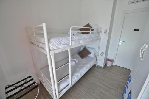 a white bunk bed in a room at Karol Wojtyla Airport Bari in Bari