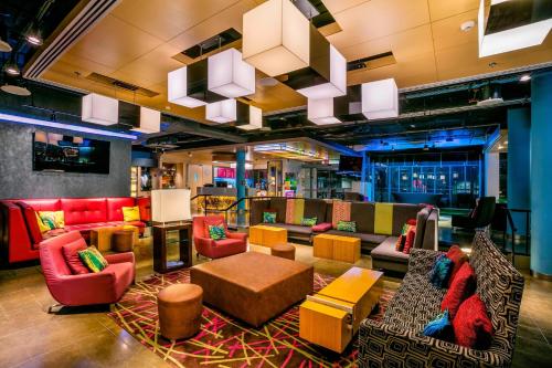 a lobby with colorful chairs and tables in a building at Aloft Bogotá Airport in Bogotá